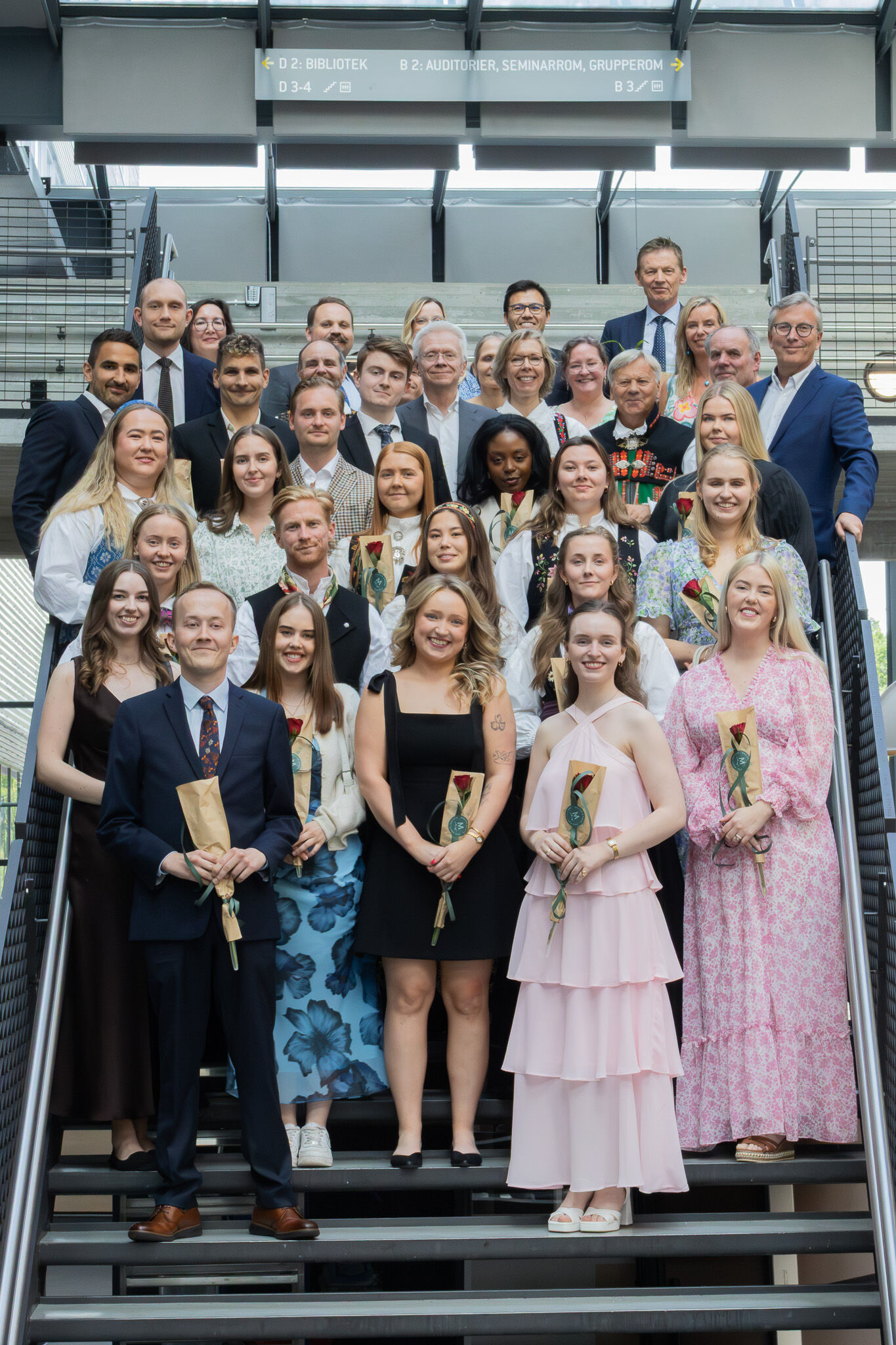 Bildet viser en rekke studenter og forelesere samlet i en trapp. 