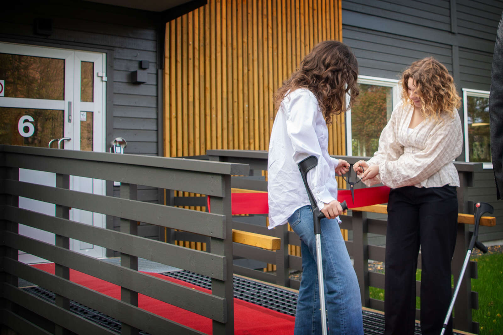 Bildet viser studentene Mari West Sandholmen og Jenny Skaar Huseby som klipper en snor utenfor instituttet.