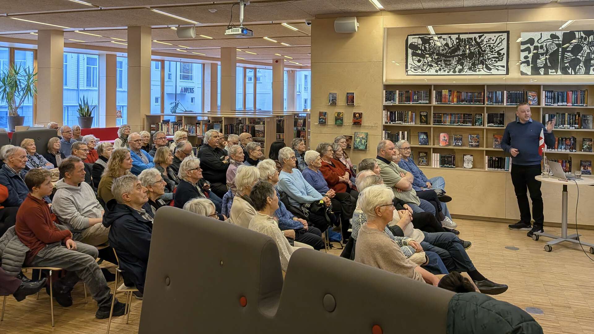 Publikum lytter til dosent ved UiA Tom Flaten holde foredrag om Grønland