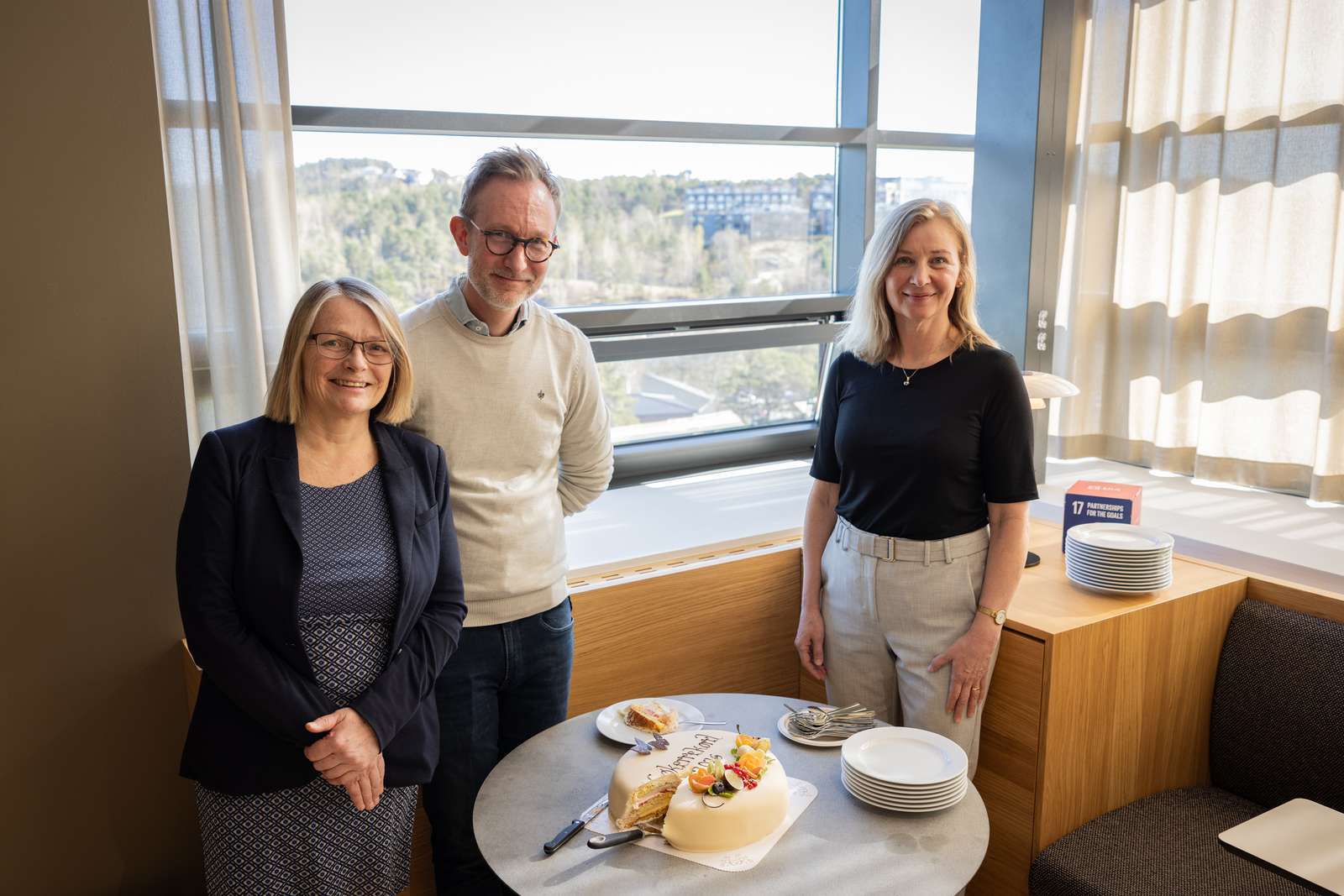 bilde av 3 ledere som feirer med kake