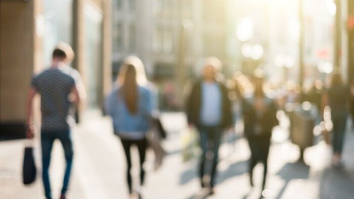 Blurry photo of people walking in a street at sunset. Stock-image.