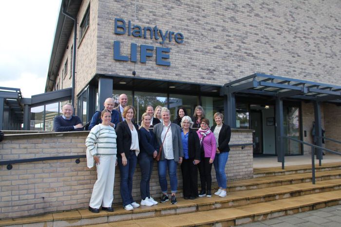 gruppebilde foran inngangen til blantyre life i skottland