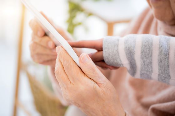 nærbilde av unge og gamle hender som holder på en telefon