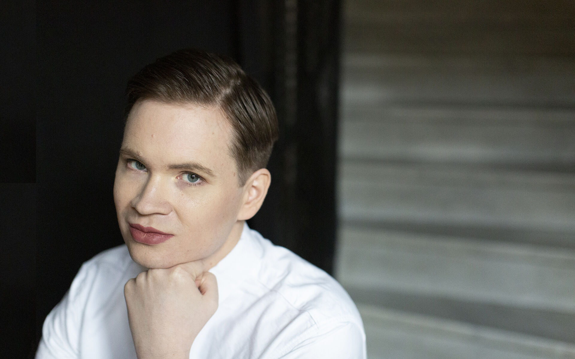 Portrettbilde av Tomas Gunnarsson, som bruker rosa leppestift og hvit t-skjorte