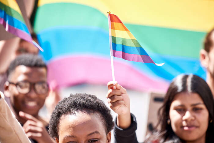 Flere personer med minoritetsbakgrunn veiver med Pride-flagg