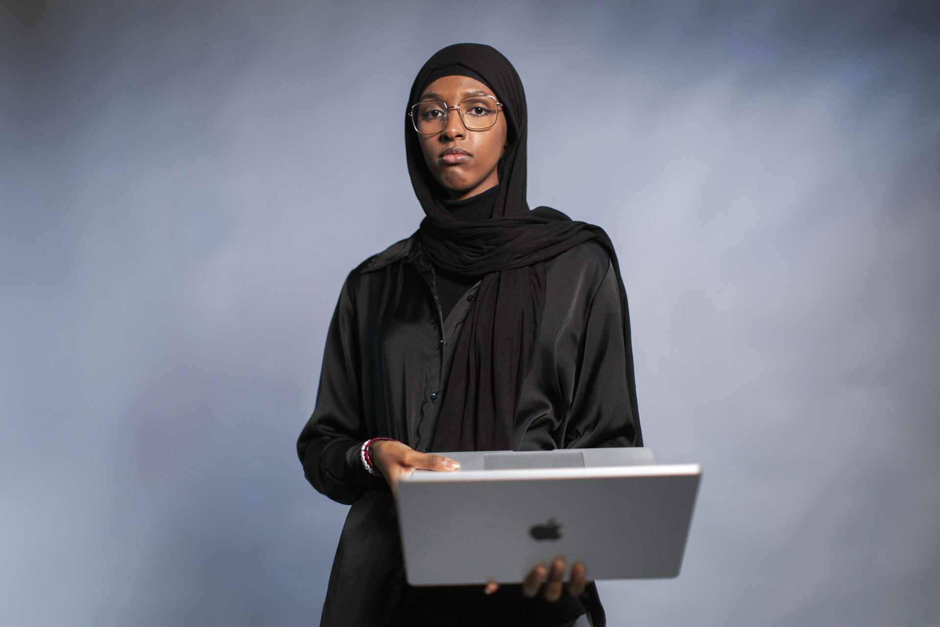 Foto av kvinne med hijab som holder en Mac