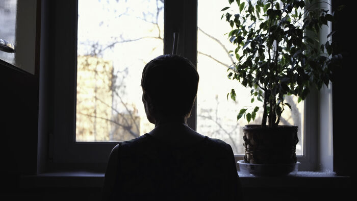 Kvinne som stirrer ut av et vindu