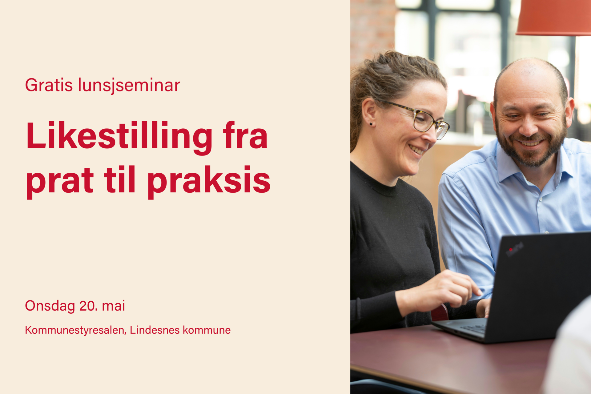 En kvinne og en mann som sitter ved siden av hverandre, smilende, foran en sort pc