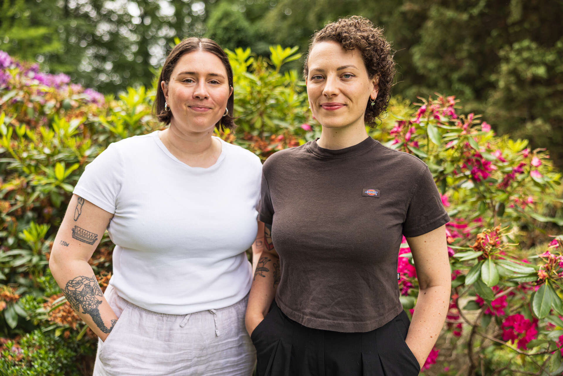 Bildet viser Mary Ann og Thea. De står og smiler mot kamera med armene i lomma.