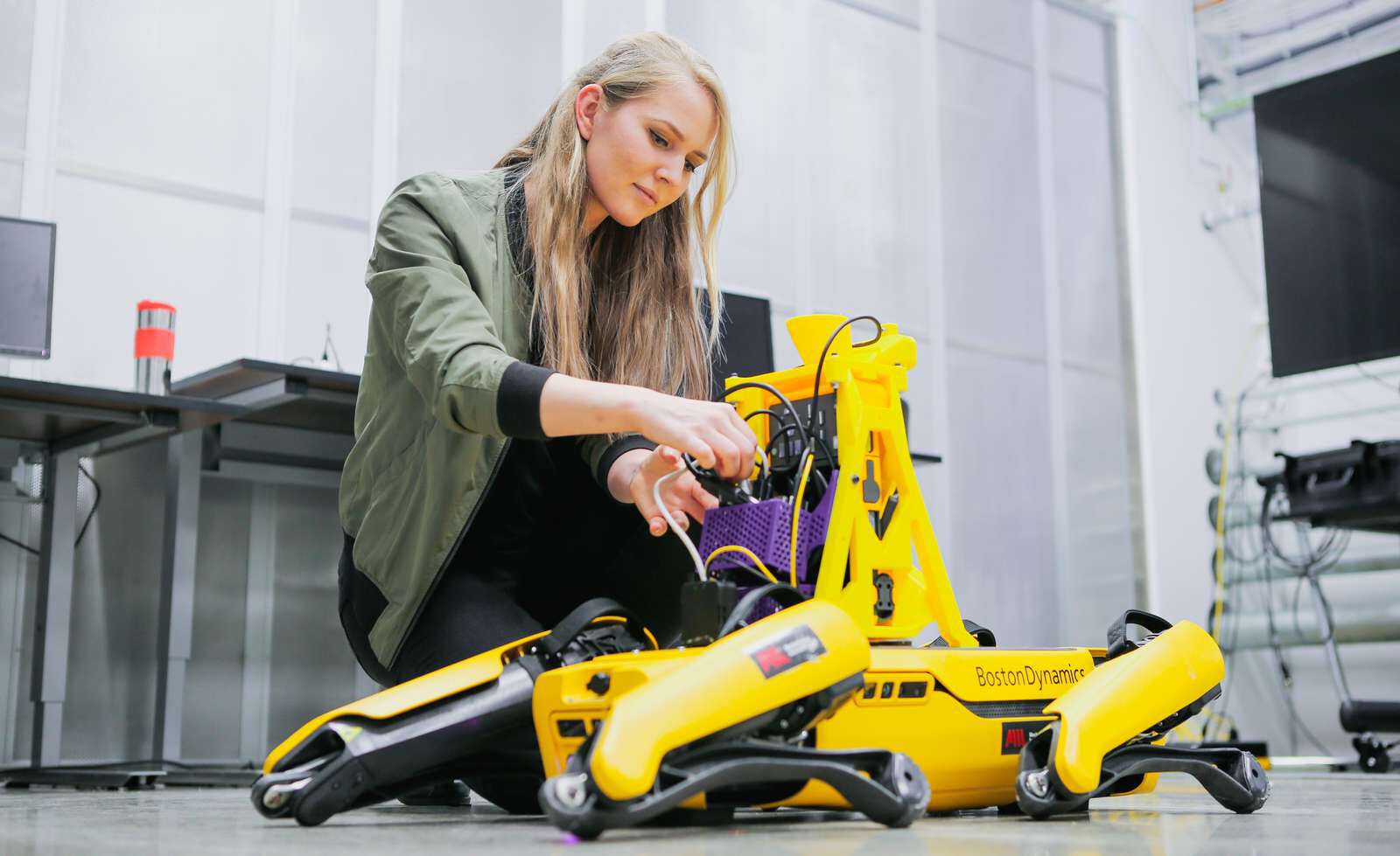 Jente som jobber med en gul robot