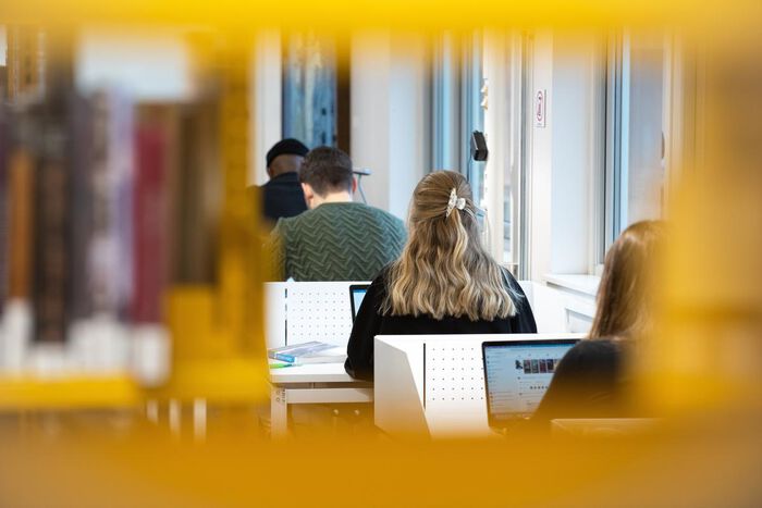 Bildet viser studenter som leser på et bibliotek.