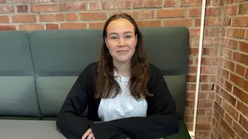 Bildet kan inneholde: smil, ansiktsuttrykk, sitter, møbler, komfort.