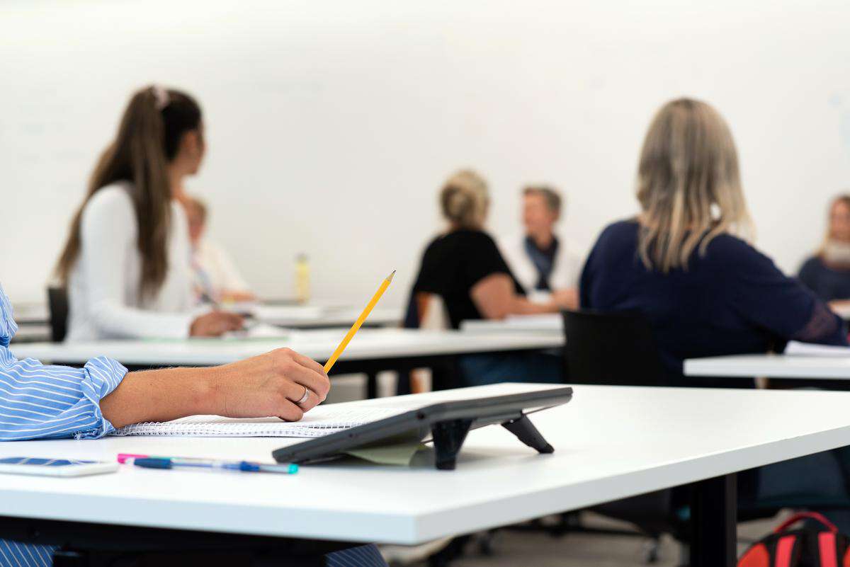 Student med skrivesaker i et klasserom