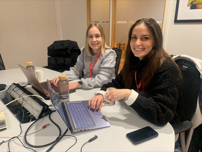 Studentene Marte Haneferd og Diella Rexha sitter på et grupperom med pcer og mobiler foran seg på pulten