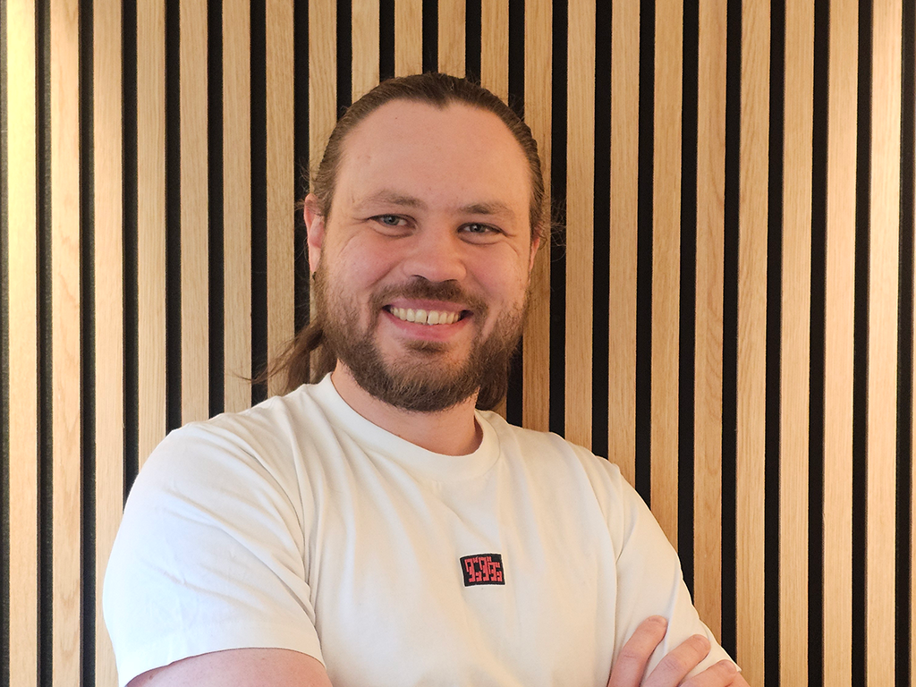 Roman ser inn i kamera og smiler