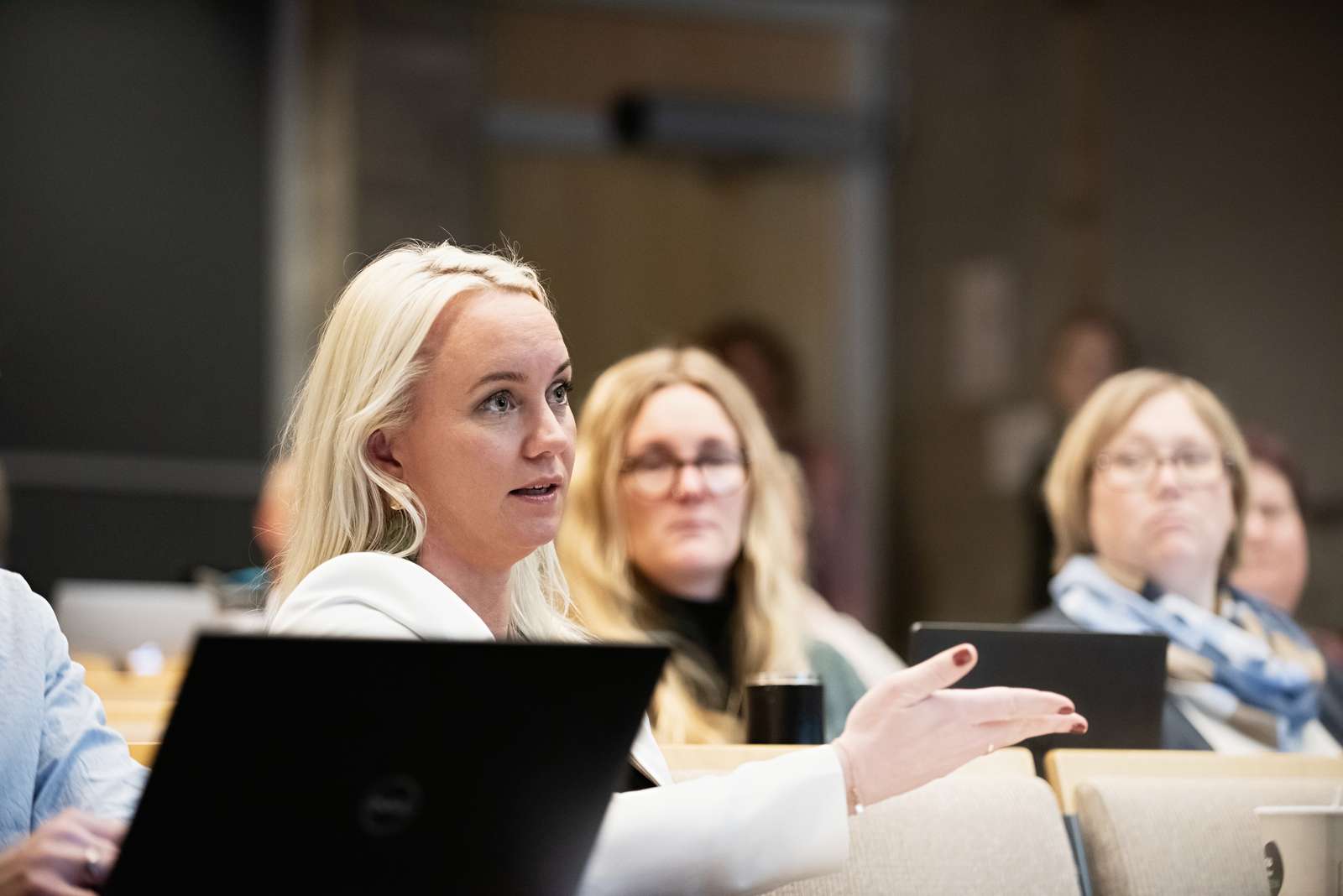 En mann i skjorte står foran en skjerm og presenterer noe til fem personer rundt et bord