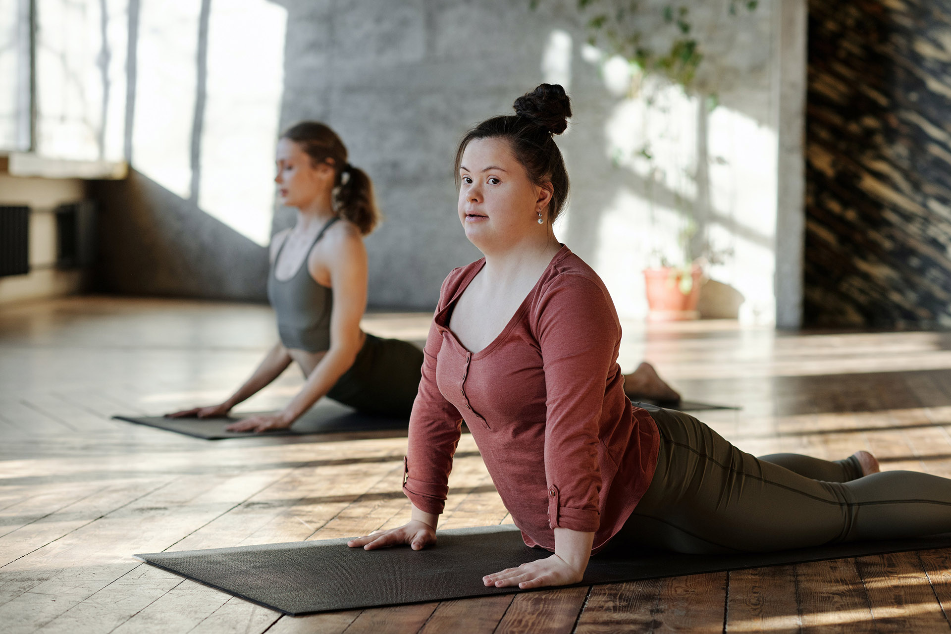 Bilde av to kvinner som gjør yoga hvor den ene har en utviklingshemming