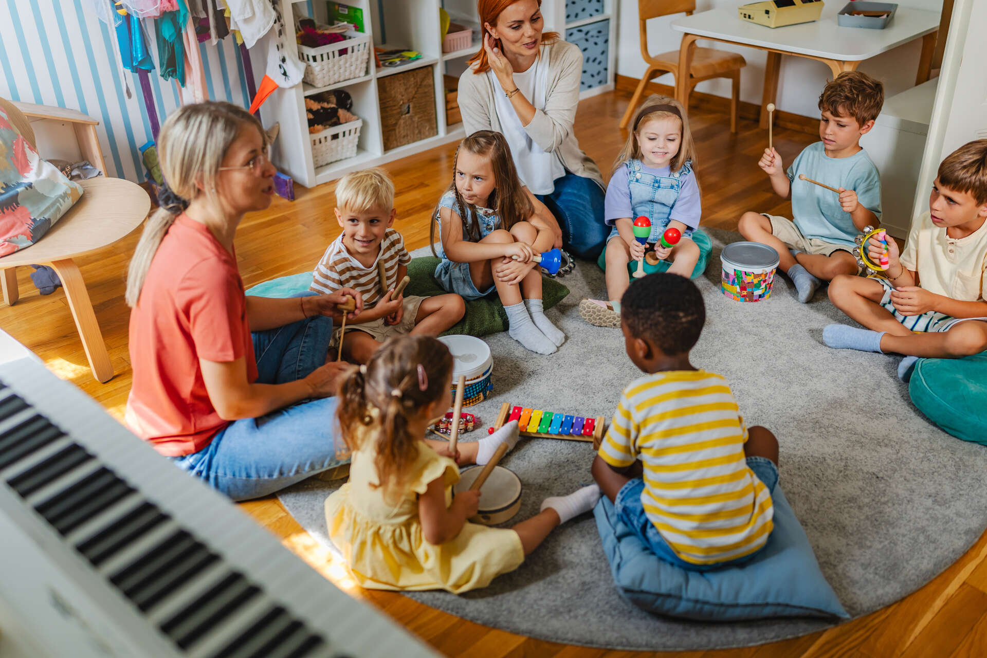 Barn sitter sammen og spiller på instrumenter i barnehagen
