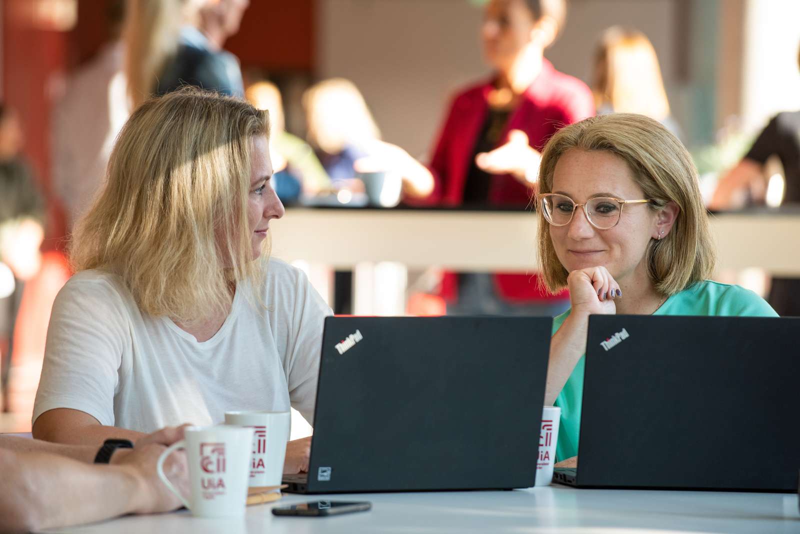 To studenter som sitter ved et bord og diskuterer