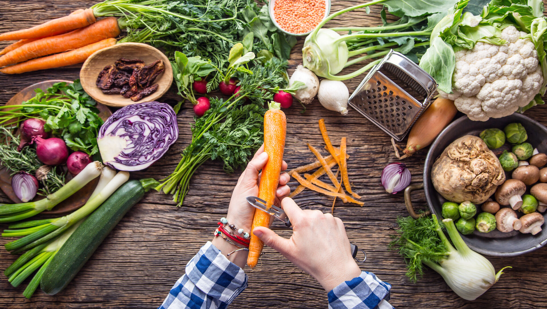 To kvinner står ved et bord med masse ingredienser og diskuterer innhold i en boks.