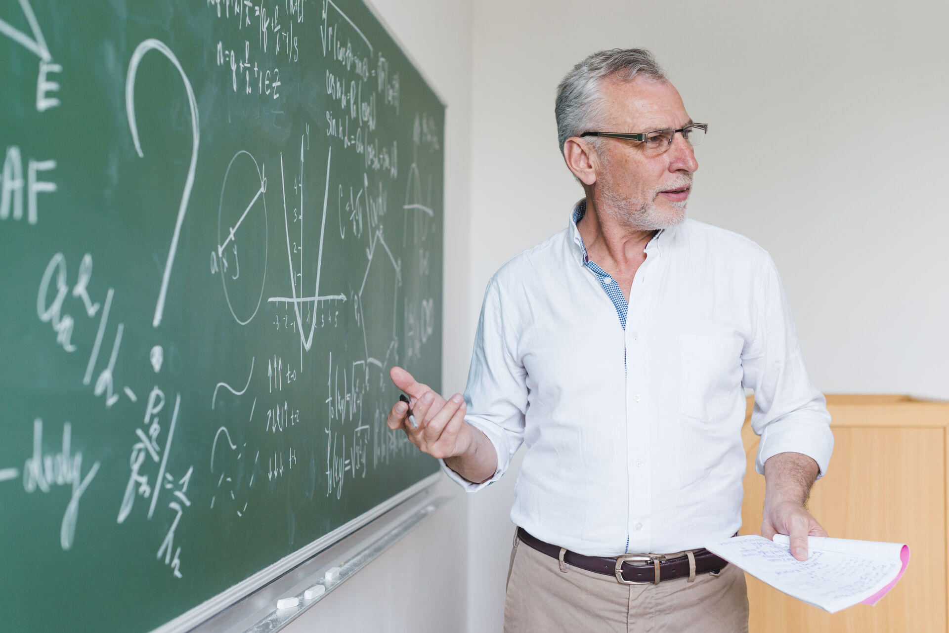 En lærer skriver matematikk på tavla