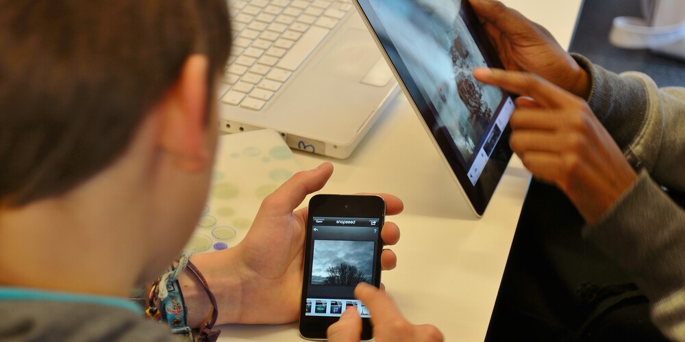 To par hender som jobber med fotoredigering på smarttelefon og tablet
