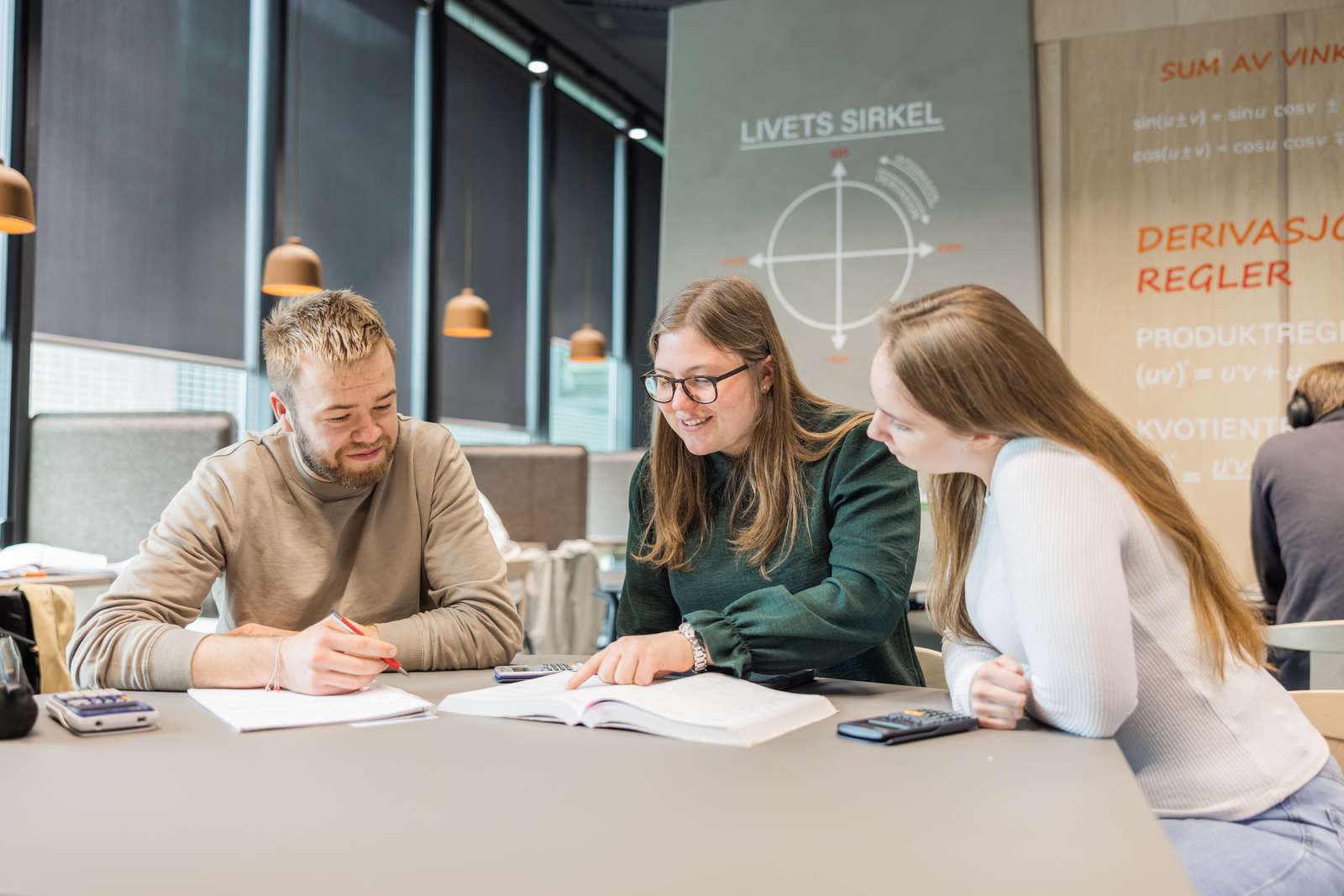 Tre studenter jobber med matteoppgaver