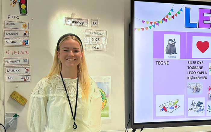 Trine står i klasserommet hun underviser i 