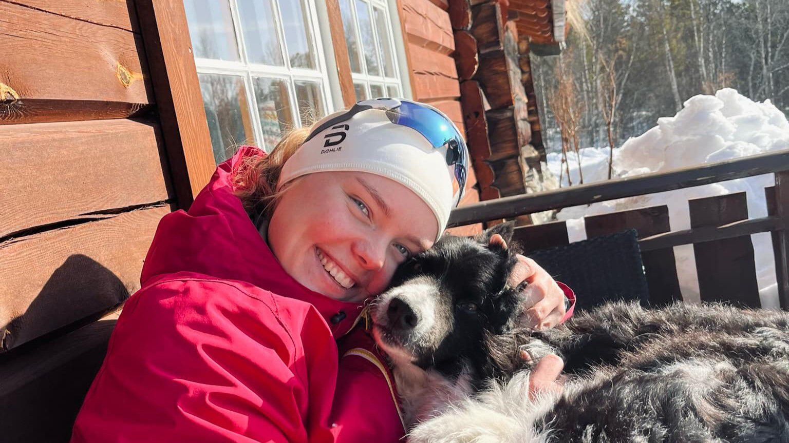 Bildet viser Mathilde med solbriller på hodet. Smiler. Båter og tresnekker i bakgrunnen.