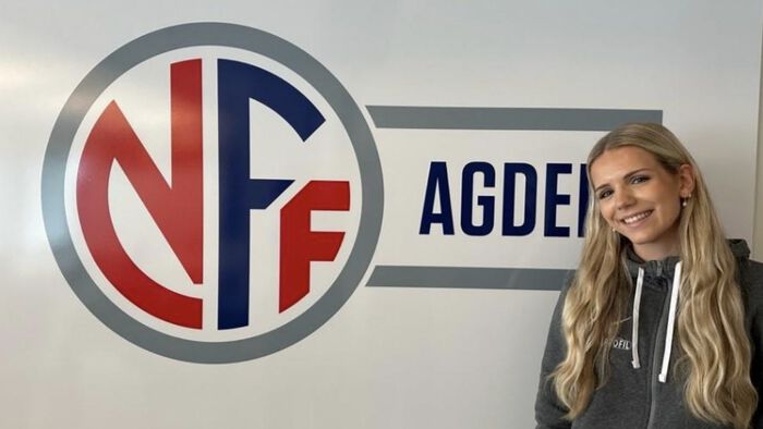 Therese Robstad-Johannesen står foran logovegg som viser NFF Agder