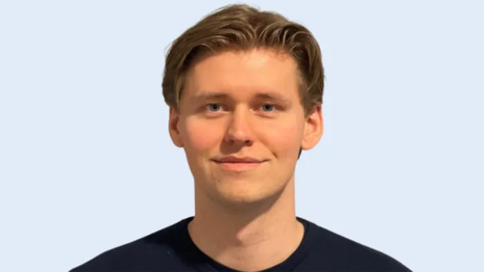 Portrett av en mann med brunt hår og svart genser 