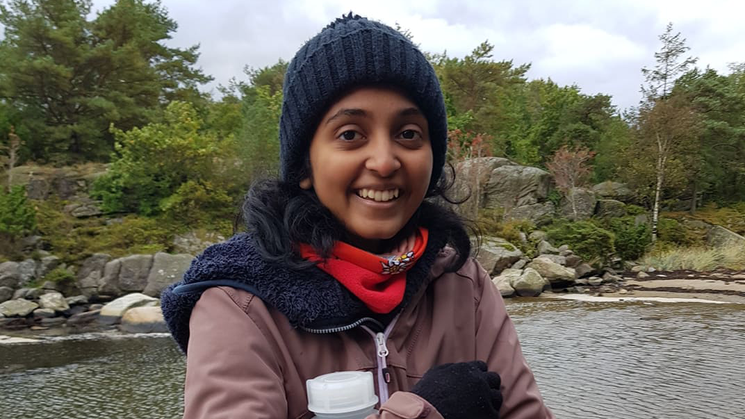 Amna ser inn i kamera og smiler