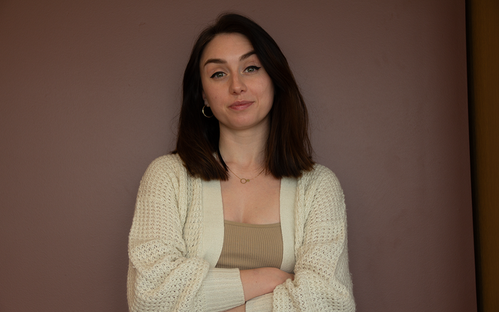 Aleksandra står med armene krysset og ser inn i kamera