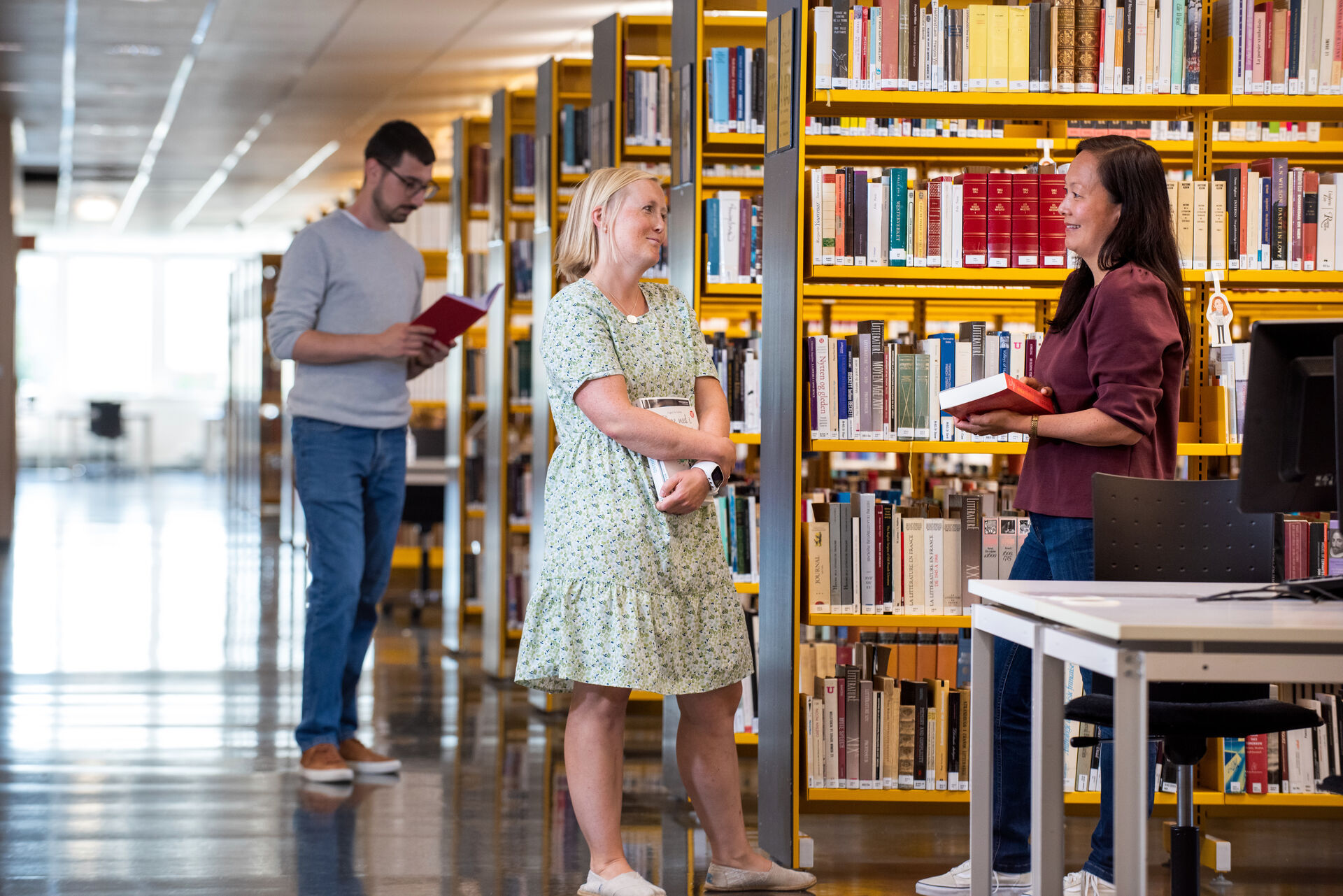 Studenter diskuterer bøker på biblioteket