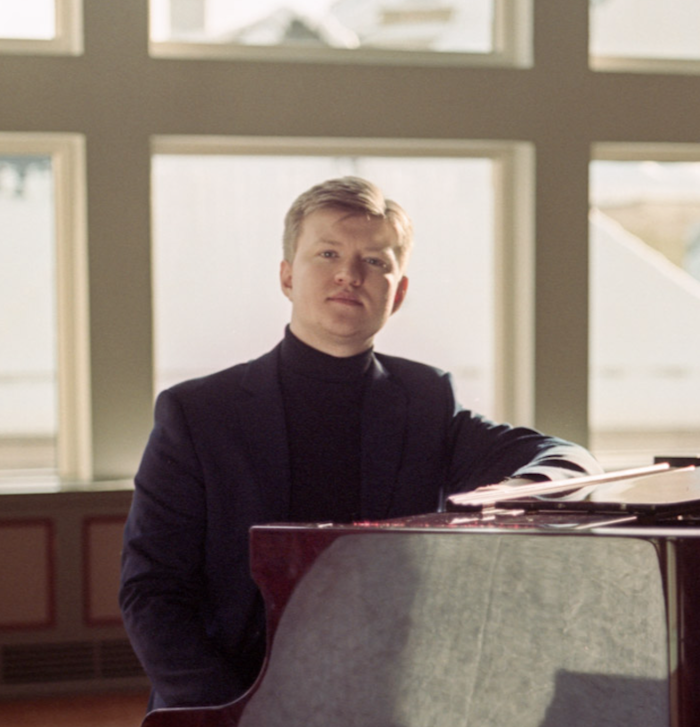 Bilde av Sivert Fluge som sitter ved et piano