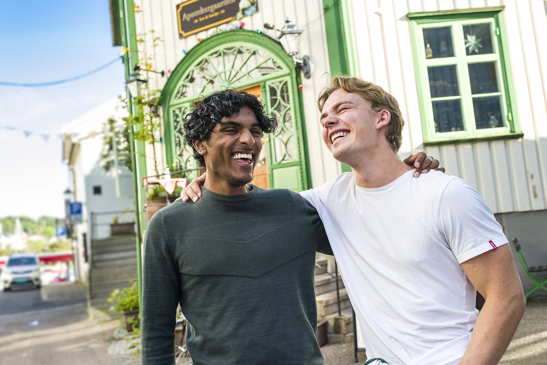 To studenter i Grimstad sentrum som smiler og holder rundt skulderen til hverandre
