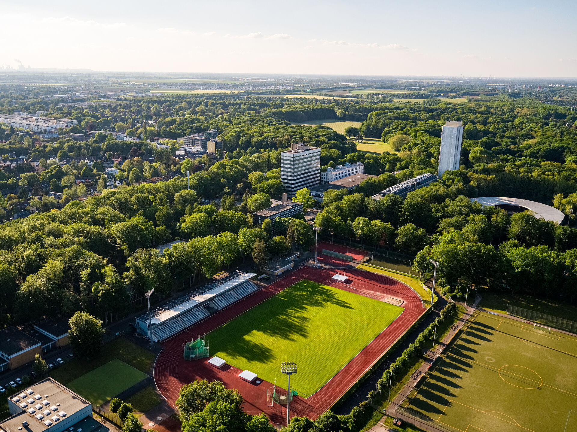 Flyfoto av campus, inkludert idrettsbane.