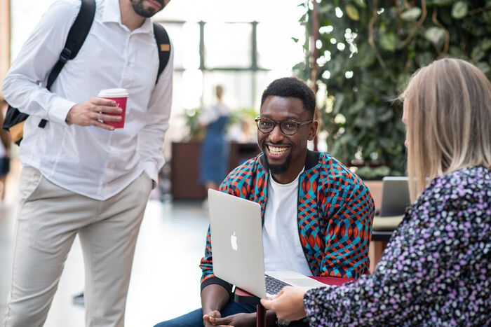 Studenter som sitter i gangen på universitetet.