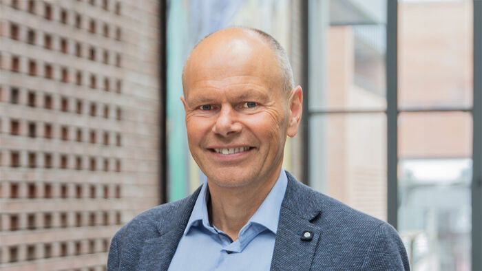 Mann, Tor Geir Kvinen, i skjorte og dressjakke smiler til kamera